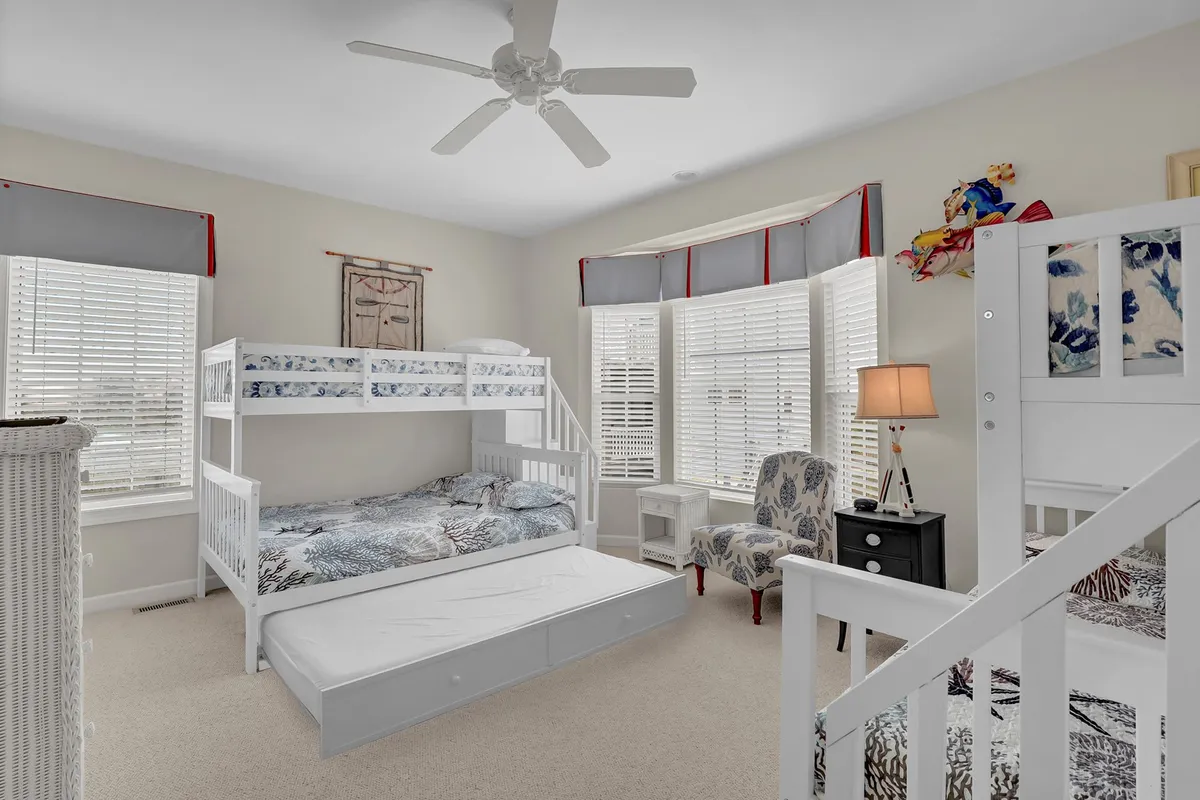 A playful and welcoming children’s room with bunk beds, a colorful armchair, and a sunlit window. The space radiates comfort and fun, ideal for sleepovers and late-night chats among siblings or cousins.